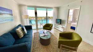 a living room with a blue couch and two chairs at Seacoast by Miami Ambassadors in Miami Beach