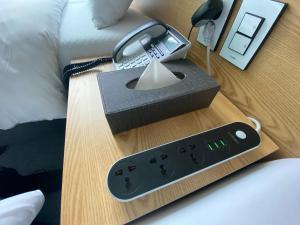 a nightstand with a clock and a lamp on a bed at Line Hotel Myeongdong in Seoul