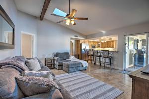 uma sala de estar com um sofá e uma ventoinha de tecto em Desert Home with Pool 5 Mi to Peoria Sports Complex em Peoria