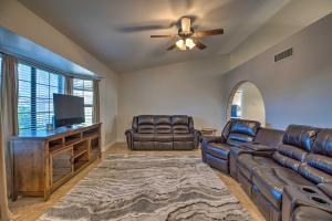 uma sala de estar com mobiliário de couro e uma ventoinha de tecto em Desert Home with Pool 5 Mi to Peoria Sports Complex em Peoria