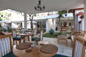 un restaurante con mesas y sillas y un patio en Sabana Ubud en Ubud
