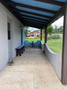 a porch with blue chairs and a bench on a house at El Viejo Adobe - Across from Sul Ross campus in Alpine