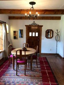 a dining room with a table and chairs and a chandelier at El Viejo Adobe - Across from Sul Ross campus in Alpine