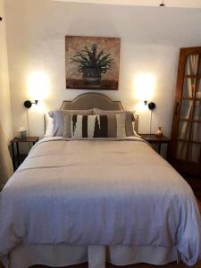 a bedroom with a large white bed with two lamps at El Viejo Adobe - Across from Sul Ross campus in Alpine