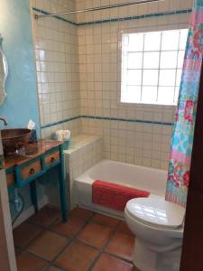 a bathroom with a tub and a toilet and a sink at El Viejo Adobe - Across from Sul Ross campus in Alpine