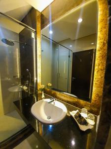 a bathroom with a sink and a mirror at Sutanraja Hotel & Convention Centre in Soreang