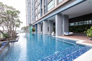 ein Pool in einem Hotel mit einem Gebäude in der Unterkunft Baan Kiang Fah Hua Hin 23-386 in Hua Hin