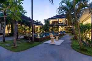 a resort with a swimming pool and palm trees at Benian Villas in Nusa Dua