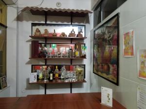 una muestra de botellas de alcohol y vasos en un estante en Hospedaje Wankko, en Huanchaco