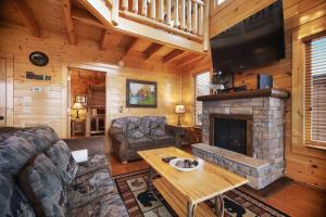 a living room with a fireplace and a flat screen tv at Livin High in Sevierville