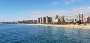 a view of a beach with buildings and the ocean at Beachfront Apartment Reñaca Chile in Viña del Mar