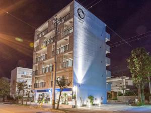 a tall blue building at night at Kariyushi Condominium Resort Miyakojima Fukugi Stays in Miyako Island +13 photos