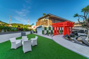 a yard with white chairs and a building at Kontena Hotel in Batu