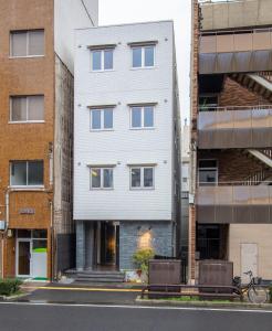 biały budynek po stronie ulicy w obiekcie GRAND BASE Takamatsu w mieście Takamatsu