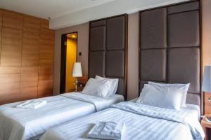 two beds sitting next to each other in a hotel room at C'haya Hotel in Kota Kinabalu