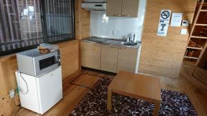 a small kitchen with a microwave and a table at 民泊和風一軒家貸し切り大人数にぴったりひろめ市場まで電車で15分の好立地 in Kochi