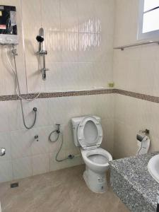 een badkamer met een douche, een toilet en een wastafel bij โรงแรมคูณคีม in Nakhon Phanom