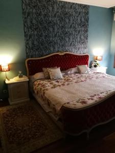 a bedroom with a bed with a red headboard at piso chalet en playa samil in Vigo