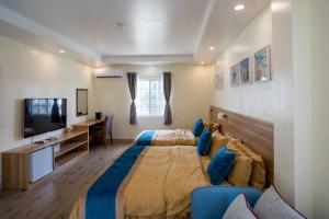 een slaapkamer met een groot bed en een bureau bij Residence Lodge in Saipan