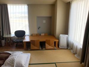 a living room with a table and chairs and a room with a table at Hotel Seagull Tenpozan Osaka in Osaka