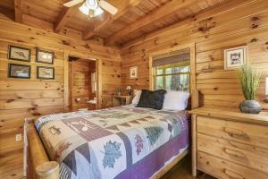 een slaapkamer met een bed in een blokhut bij Mountain Serenity Cabin in Sevierville