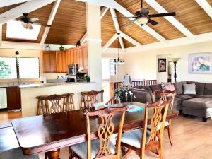eine Küche und ein Wohnzimmer mit einem Holztisch und Stühlen in der Unterkunft Ocean Breeze Kona Home in Kailua-Kona