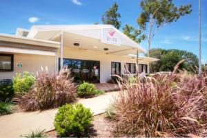 un edificio con piante di fronte ad esso di Weipa Motel Resort a Weipa