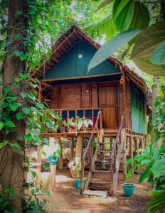 a wooden house with a table and chairs in front of it at Brookline Safari Resort in Udawalawe