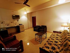 a living room with a couch and chairs and a table at TGF Dream Guest House in Majorda