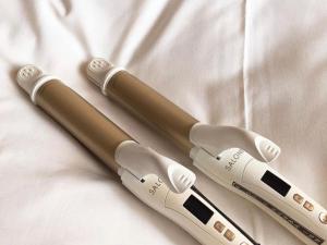 two remotes laying on top of a white sheet at Nisshin Namba Inn in Osaka