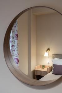 a mirror reflecting a bedroom with a bed and a table at Absolute Athens XI in Athens