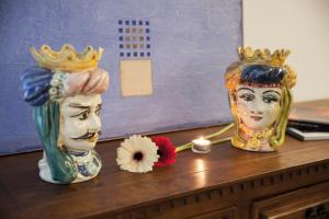 dos jarrones con coronas encima de una mesa en Casa di Sara en Zafferana Etnea