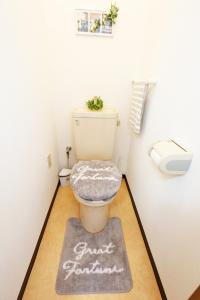 uma casa de banho com um WC com uma placa no chão em Lucky Yotsugi em Tóquio