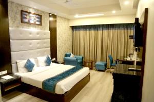 钱德加尔Hotel Shagun Chandigarh Zirakpur的一间带床、桌椅的酒店房间 更多37张照片