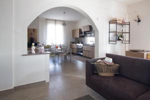 sala de estar y cocina con sofá y mesa en Casa di Sara en Zafferana Etnea