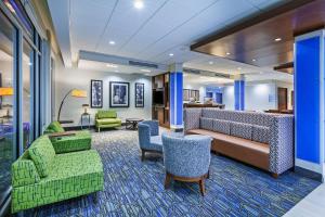 eine Hotellobby mit grünen Stühlen und einer Couch in der Unterkunft Holiday Inn Express & Suites - Tulsa Northeast - Owasso, an IHG Hotel in Owasso