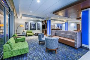 een hotellobby met groene stoelen en een bank bij Holiday Inn Express & Suites - Tulsa Northeast - Owasso, an IHG Hotel in Owasso