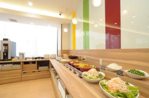 a buffet line with bowls of food in a restaurant at AB Hotel Ubeshinkawa in Ube