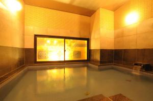 a swimming pool in a room with a window at AB Hotel Ubeshinkawa in Ube