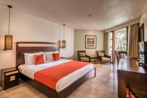 a hotel room with a bed and a desk and chairs at The Warwick Fiji in Korolevu