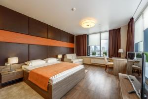 a hotel room with a bed and a desk and a television at RADIUS Central House in Yekaterinburg