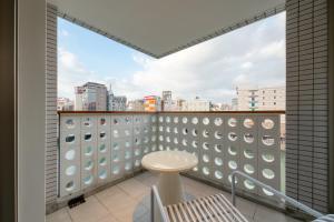 a balcony with a table and a view of a city at The OneFive Villa Fukuoka in Fukuoka