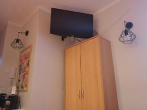 a tv on the corner of a room with a cabinet at Apartament Kortowski in Olsztyn