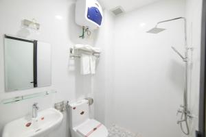 a white bathroom with a toilet and a sink at Asean Garden Homestay Hue in Hue