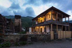 a large wooden house with the lights on at Agra Ushguli in Ushguli