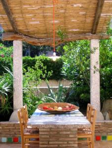 uma mesa com uma tigela de fruta em Casa Baia em Capo Testa