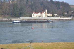Gasthof s'Schatzkastl في Ardagger Markt: قارب في الماء مع مبنى في الخلف