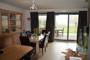 a dining room with a table and chairs and a view of a patio at Residentie Pelikaan - nice view on the Leie in Deinze