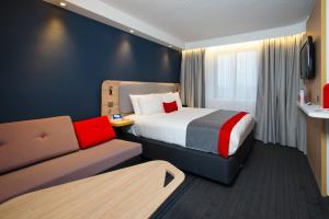 a hotel room with a bed and a couch at Holiday Inn Express Edinburgh - Leith Waterfront by IHG in Edinburgh