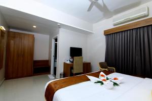 una habitación de hotel con una cama con flores. en HOTEL PANACEA VENTURES, en Kollam